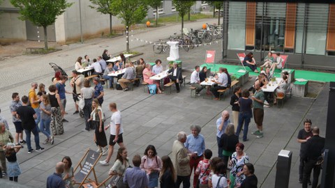 Menschen stehen in Gruppen vor dem Biologie Gebäude