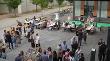 Menschen stehen in Gruppen vor dem Biologie Gebäude