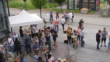 Vor dem Biologie Gebäude stehen Menschen mit Getränken