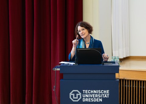 Frau in blauem Blazer steht an dem TU Dresden Pult und spricht zum Publikum