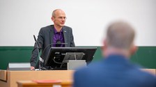 Prof. Carsten Timm spricht am Pult.