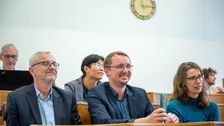 Gäste im Hörsaal mit fröhlichen Gesichtern.