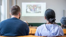 Zwei Menschen werden von hinten gezeigt.
