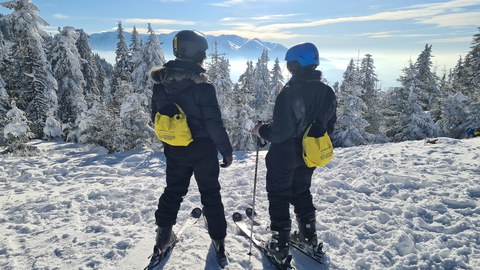 Foto von zwei Peronsen mit Skiern im Schnee