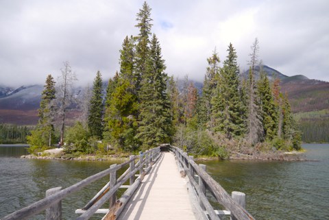 Bridge leading to a wooded island on a lake