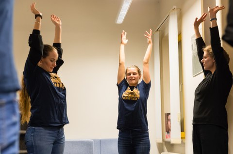 Drei Studierende strecken ihre Arme während des Pausen-Yogas.
