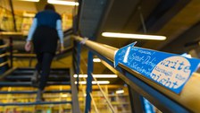 Ein nachtblauer Pfeil mit einem gelben Mond weist den Weg die Treppe hinauf zum "SPeed-Dating für Lern- und Schreibgruppen". Im Hintergrund läuft eine Person die Treppe hinauf.