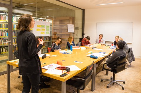 Eine Gruppe Studierender sitzt in einem Arbeitsraum der SLUB zusammen in einem Workshop des Schreibzentrums.
