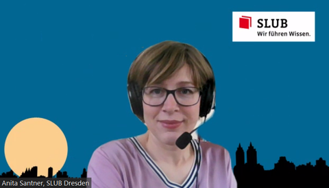 Screenshot of Anita Santner in a video call against a background in blue, a city backdrop at the bottom, a yellow moon at the bottom left, the SLUB logo at the top right.