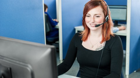 Mitarbeiterin telefoniert in der Hotline