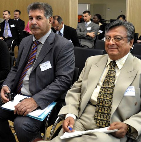 The photo shows two people in suits at an event.
