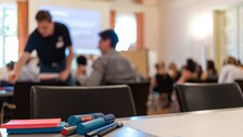 Blick über einen Workshoptisch in den Saal