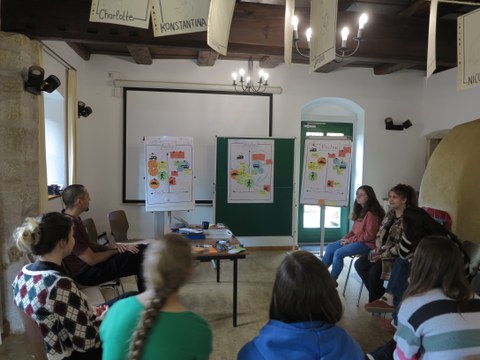 Foto vom Workshop, das die Teilnehmenden und Adam im Stuhlkreis zeigt.