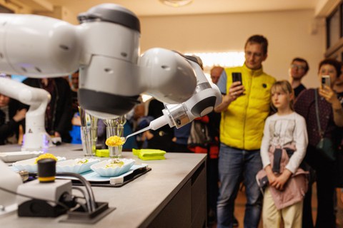 Menschen schauen auf Roboter, der Essen serviert