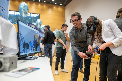 Ein Mann zeigt einer Frau eine VR-Brille.