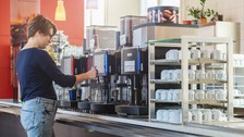 Studentin am Kaffeeautomat Zebradiele