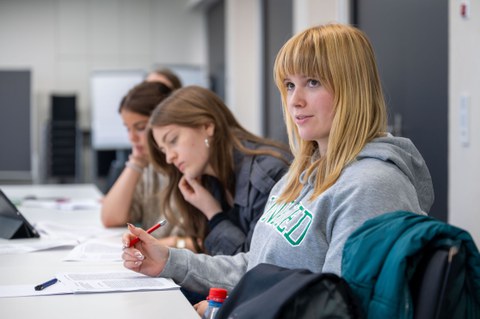 Teilnehmerinnen hören zu und machen sich Notizen