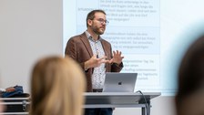 Ein Dozent erklärt einen Sachverhalt zum Thema Zeit