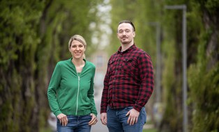 Zu sehen sind Antonia Zacharias-Weihs und Konrad Schrötter. Sie lächeln in die Kamera. Es ist das Gruppenfoto des Sommeruni-Teams.