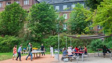 Foto: Eine Gruppe spielt Tischtennis neben dem gut besuchten Grill Cube am Hörsaalzentrum.