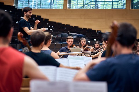 Foto einer Orchesterprobe des Universitätsorchester in einem Hörsaal