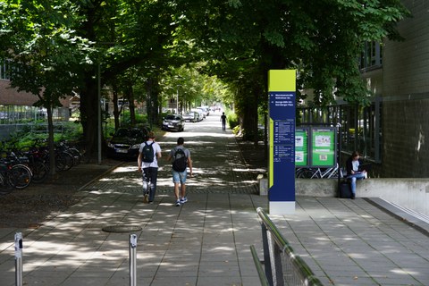 Photo of two women standing in front of a map of the TUD campus and pointing to it
