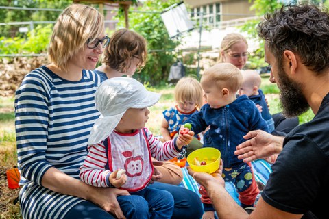 Foto von Eltern mit ihren Kindern auf einer Wiese