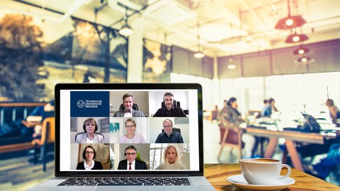 Computer on a table in a cafe showing members of the rectorate in a video conference