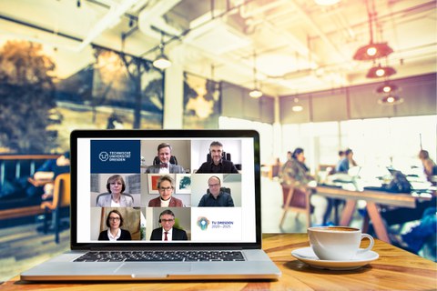 unfolded laptop on table in a cafe, on the screen of which the members of the Extended University Executive Board can be seen in a video conference