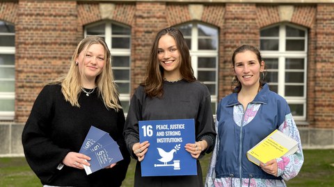 Engagierte bei Refugee Law Clinic mit Tafel von SDG 16