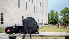 Das Foto zeigt die Rückseite der Sächsischen Landes- und Universitätsbibliothek. Im Vordergrund steht eine Bank. Auf dieser liegen ein Rucksack und ein Skateboard.