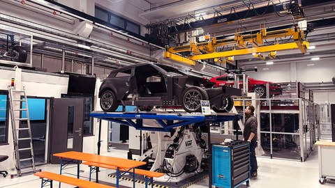 Foto eines nur zum Teil montierten Autos auf einer Hebebühne 