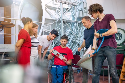 Sechs Menschen begutachten ein technisches Gerät.