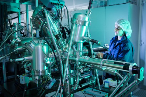 Eine Wissenschaftlerin arbeitet im Reinraum-Labor mit komplexer Technik.