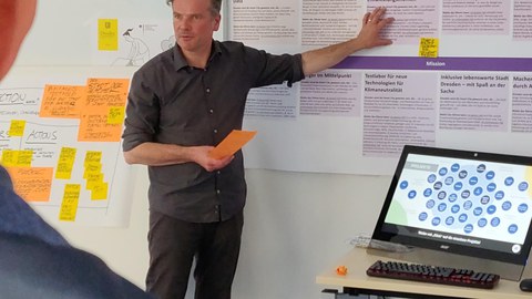 Professor Noennig steht an einer Tafel und spricht in den Raum.