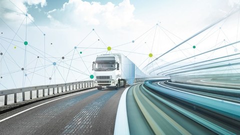 Ein LKW fährt auf einer Brücke auf den Betrachter zu.
