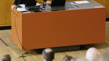 Die Rektorin steht an einem Pult und spricht.
