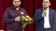 Foto von 2 Vetretern der Student Welcome Initiative, die einen Preis gewonnen haben.