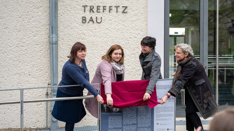 Vier Frauen enthüllen eine Tafel.