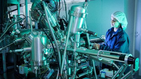 Junge Frau arbeitet an einer wissenschaftlichen Apparatur.