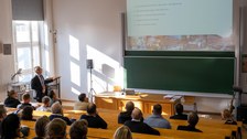 Personen folgen einem Vortrag mit einer Präsentation