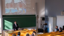 Personen folgen einem Vortrag mit einer Präsentation.