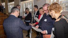 Mehrere Personen bekommen eine Urkunde überreicht.