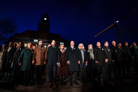 Fotoaufnahme von mehreren Menschen, die sich an den Händen halten und eine Menschenkette bilden.