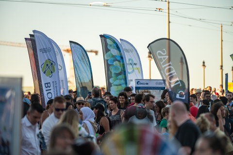 Foto von vielen Menschen auf der Augustusbrücke in Dresden, die dicht an dicht stehen. Im Hintergrund sieht Fahnen mit TU Dresden-Logo erkennbar.