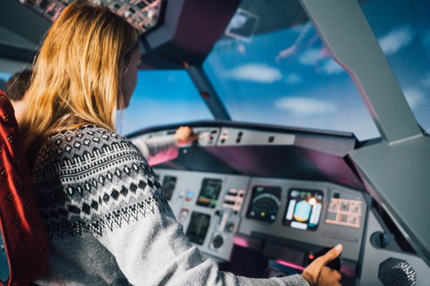 Fotoaufnahme einer Frau, die in einem Flugsimulator sitzt.