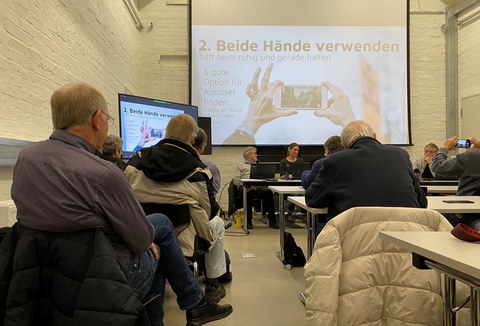 Fotografieren mit dem Handy: Hörerinnen und Hörer der Seniorenakademie machen sich dazu bei einem Vortrag im Medienkulturzentrum schlau.