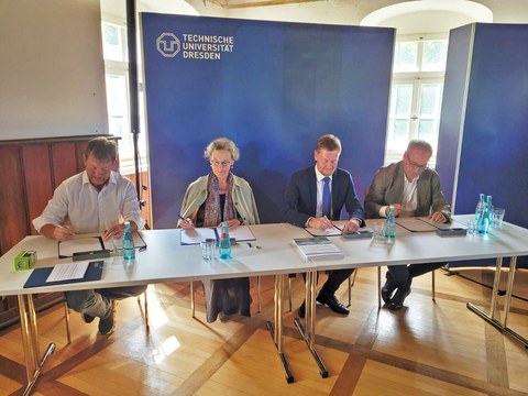 Sachsens Ministerpräsident Michael Kretschmer (2.v.r.), TUD-Rektorin Prof.in Ursula Staudinger (2.v.l.), Jan Gerken, Kanzler der TU Dresden (r.) und Silvio Ziesemer, Bürgermeister der Stadt Tharandt (l.) bei der Unterzeichnung der Urkunde.