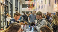 Fotoaufnahme von Menschen an einem Stand im Chemiegebäude der TU Dresden.
