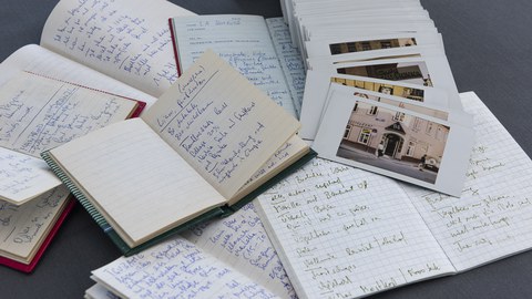 Aufgeschlagene Notizbücher und Fotografien aus der Sammlung von Christoph Wagner.